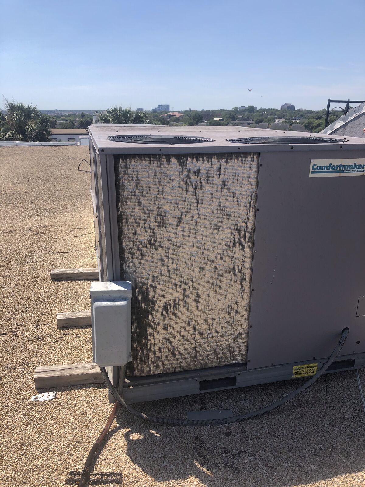 Dirty condenser coil on a rooftop unit before maintenance